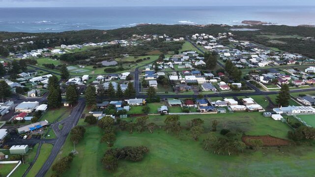 Sunrise over Beachport, South Australia: 4K aerial drone footage of coastal town, low density houses, estates, jetty, calm ocean, Southern Ocean Beach and golden morning light.