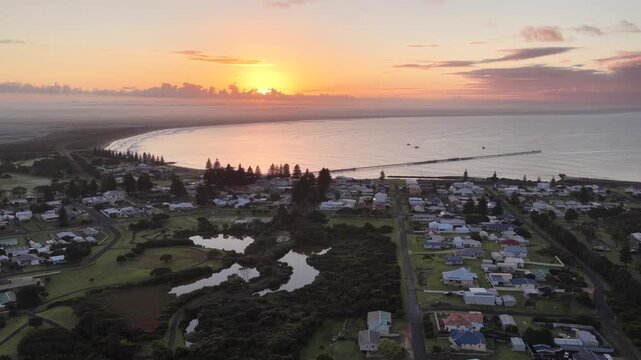 Beachport, South Australia at sunrise: 4K aerial drone footage of coastal town, jetty, calm ocean, Southern Ocean Beach and golden morning light