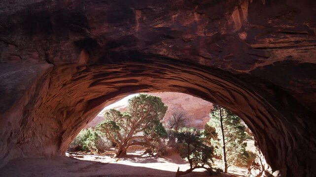 View through a natural rock arch in desert landscape.
