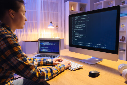 Female programmer working with computer in office at night