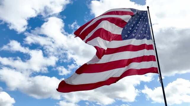 Patriotic American Flag Moving in Breeze Under Blue Sky