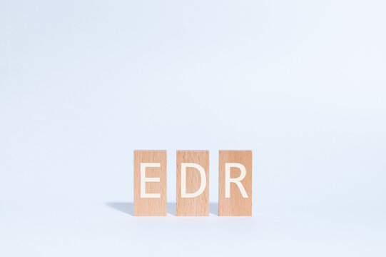 Eye-catching image of EDR text on wood blocks. The word stands for Endpoint Detection and Response.