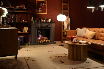 Obraz premium Interior of dark living room decorated for Halloween with sofa, fireplace and glowing lamps