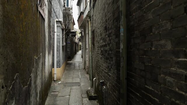 Walking through narrow old Chinese alley with brick walls and traditional buildings urban passage perspective cinematic video still Guangzhou China