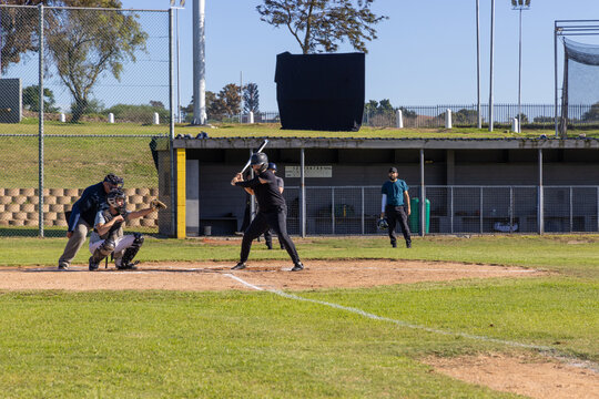 Pitch arriving, batter swinging bat scoring run, catcher catching, umpire signaling strike