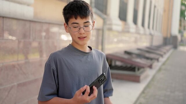 Upset young person reading bad news on smartphone and sighing with frustration in city street. Real people, authentic emotions, stress and disappointment concept.