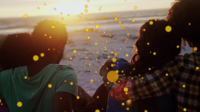 4 pals sitting on sand watching sun sinking, yellow particles overlay, fixing blue hat marketing