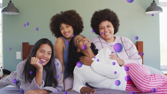 4 women on bed sharing looks sparking laughter bonding lifestyle, purple dots drifting across faces