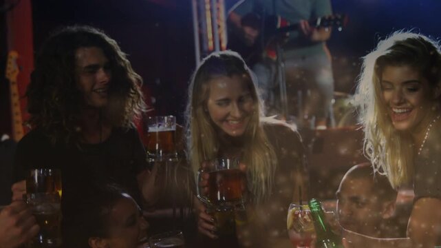 Friends leaning table in bar guitar playing cheering clinking green bottle,mug bokeh across frame