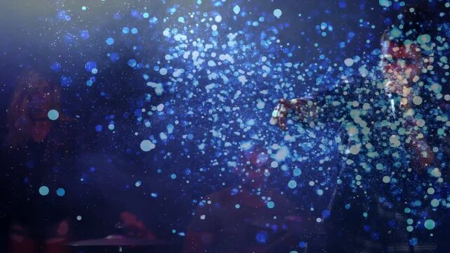 Two singers singing left, cue sparking blue confetti, male singer stepping into cloud leading music