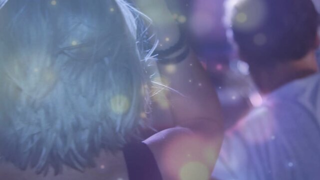 Female attendee adjusting hair to music beat in concert, with animated bokeh sweeping wristwatch
