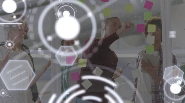 Business team at glass, writer stepping placing sticky notes to set goals while HUD obscuring faces