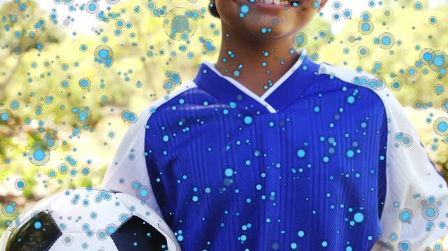 Blue particle overlay appearing, widening camera, revealing boy holding ball and smiling for sports