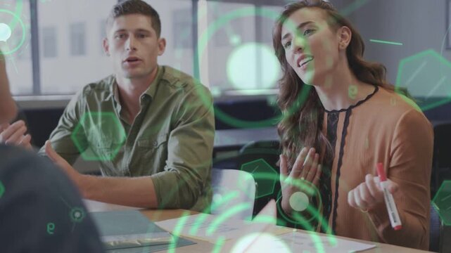 Woman raising marker leading business meeting while man nodding green hex and circle overlay moving