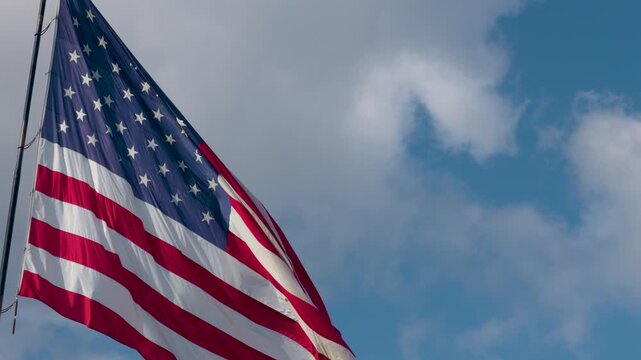 Slow Motion American Flag Waving with Copy Space Against Blue Sky
