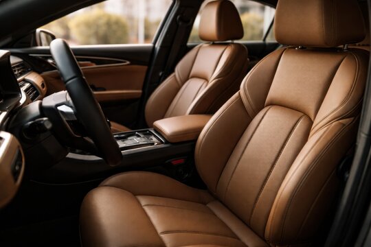 luxury car interior with tan leather seats and steering wheel in warm sunlight