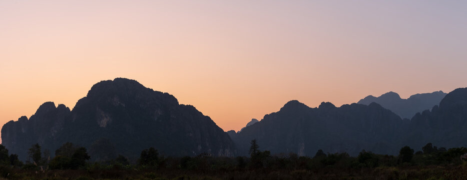 Beautiful natural panoramic countryside landscape with mountains at sunset. Nature background.