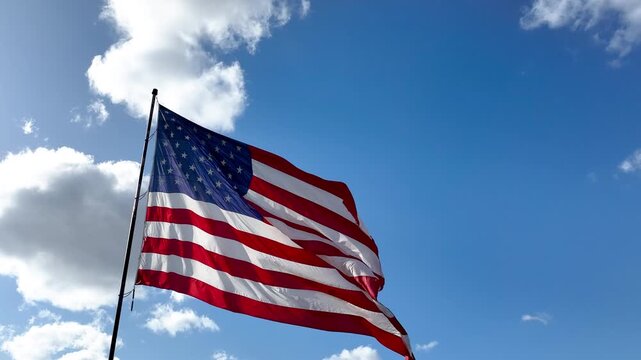 Cinematic Orbit Shot of American Flag Waving Against Cloudy Sky