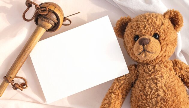 Sweet brown teddy bear, blank white card for personalized messages, unique wooden rattle on soft white fabric, perfect for baby showers