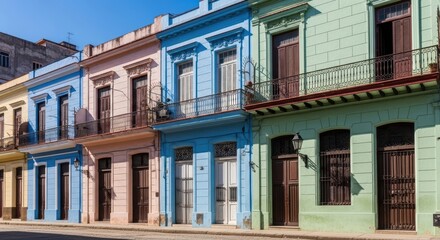 Obraz premium Colorful Cuban colonial houses line sunny Havana street with vibrant pastel colors and architecture