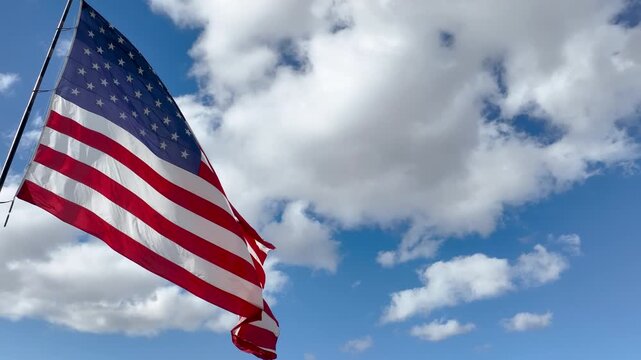 United States Flag Waving in Wind with Clouds and Sunshine