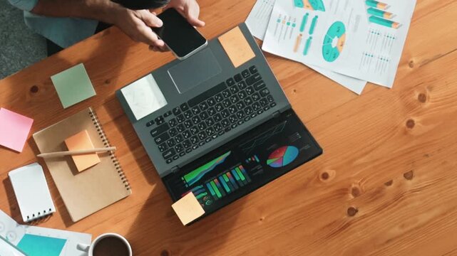 Businessman stick sticky notes on laptop displayed financial graph while talking phone with manager at meeting table with note and paper work. Leader brainstorm with team by using phone. Convocation.