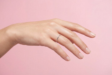 Naklejka premium Female hand with ring indicating pause on pink background
