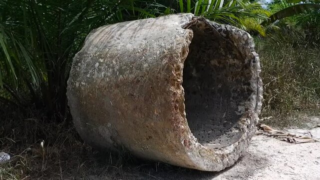 Old broken concrete culvert pipe abandoned on a rural roadside