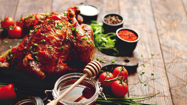 roasted whole chicken or turkey served on wooden chopping board with chilli pepers