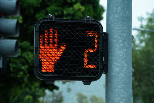 Red hand symbol and countdown timer on pedestrian crossing signal