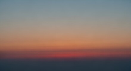 Obraz premium Serene twilight sky with soft hazy horizon transitioning from deep blue to warm orange tones