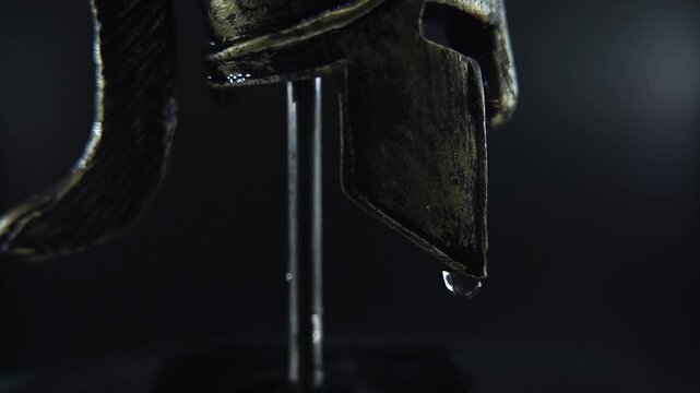 Slow motion rotation of ancient Spartan helmet, emphasizing metallic detail and wet texture