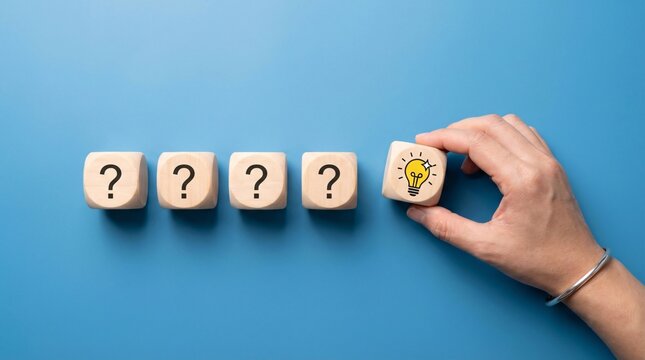 Hand placing a wooden cube with a glowing lightbulb symbol onto a row of cubes with question marks representing finding a solution innovation and a brilliant idea emerging