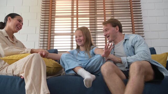 Families play together on the sofa during holidays at home, fostering bonding and spending quality time together