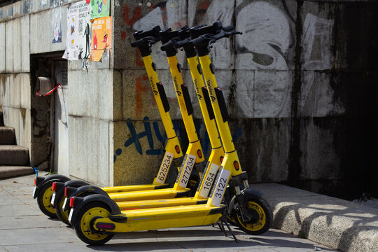 Tbilisi, Georgia - April 23, 2026: Horizontal photo. Row of yellow electric scooter with Yandex Go logo on city street parking lot. Concept of kick scooter sharing, job, rental, road trip, green power
