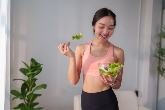 Young woman enjoying healthy fresh salad for fitness