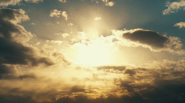 A heavenly timelapse of a cloudy sky with a bright golden sun. Extraordinary natural beauty.