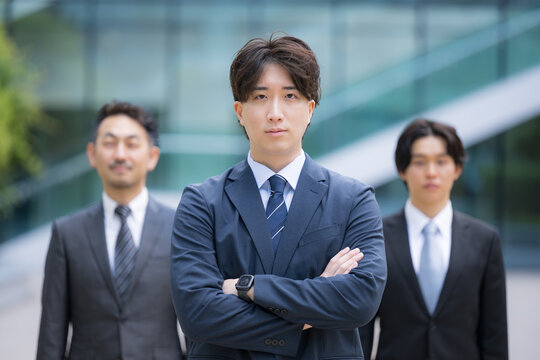 信頼感ある中堅サラリーマンのビジネスチームのポートレート企業成長と組織力イメージ　士業やコンサルタントなどの3人複数のビジネスシーンカメラ目線笑顔　腕を組む