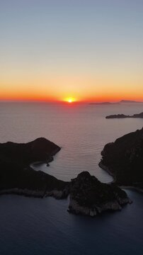 Aerial vertical view of spectacular sunset over Porto Timoni double beach and Afionas in Corfu, Greece. Stunning Ionian sea landscape