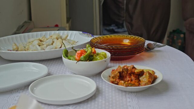 Hands arranging plates and authentic spicy side dishes for Eid al-Adha family feast