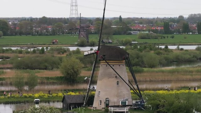 Telezoom drone shot orbiting a old Windmills in the marshlands of Netherlands