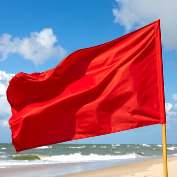 A red flag waves on a beach
