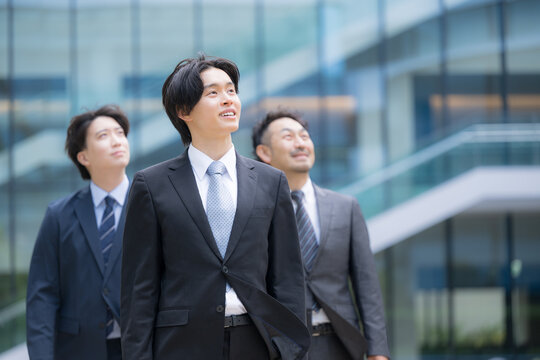 笑顔で歩くスーツで新卒採用や新人の若手ビジネスチームのポジティブ(前向き)な未来を見つめる(見上げる)リクルートイメージ　転職や就活、採用などの笑顔複数の横並び