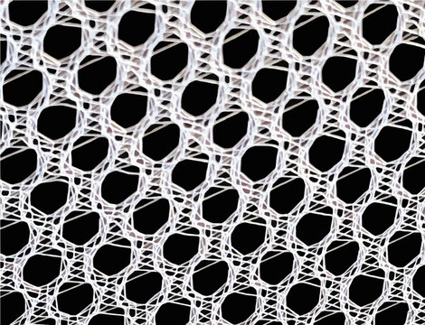 Close-up macro shot of a white hexagonal mesh fabric showing intricate woven synthetic fibers against a high contrast solid black background.