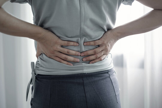 Woman having back body pain during work long time. stretching to relax and relax while working hard at the office