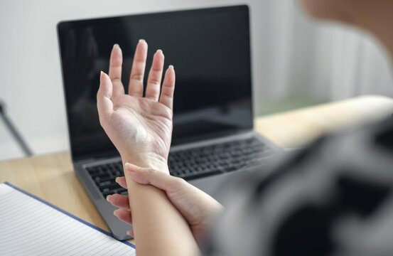 Woman hand with wrist pain numbness and pain in the palm of the hand has pain and tingling in the nerve endings This is a side effect of sitting and working for a long time on a laptop at the office
