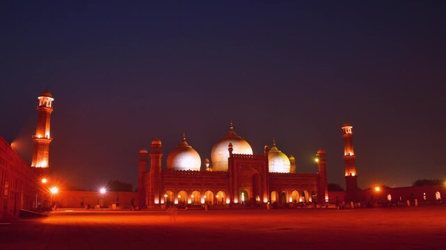Lahore, Pakistan - 24th october, 2024: Badshahi mosque Lahore timelapse day to night transition glowing domes minarets courtyard lights historic mughal architecture pakistan landmark twilight