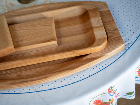 Wooden plates and divided trays made of laminated wood for traditional Slovak dishes like bryndzov&eacute; halu&scaron;ky or pierogi, rustic style.