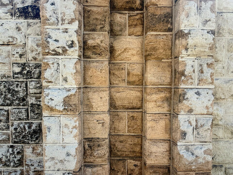 Old Stone Wall Texture with Central Brick Column and Weathered Masonry Blocks