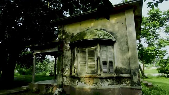 Old house with a bay window and shutters in a natural setting with trees